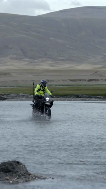 Vertical Shot of Adventure Motorcyclist Crossing River in Ladakh, India