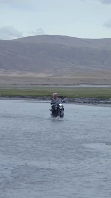 Vertical Shot of Adventure Motorcyclist Crossing River in Ladakh, India