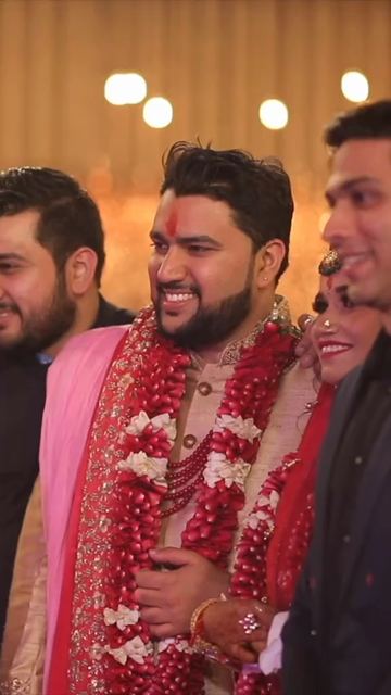 Vertical Shot of Bride and Groom Posing with Relatives at Their Indian Wedding