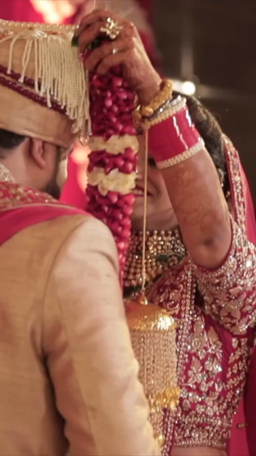 Vertical Shot of Bride and Groom During Jaimala Ceremony at Indian Wedding