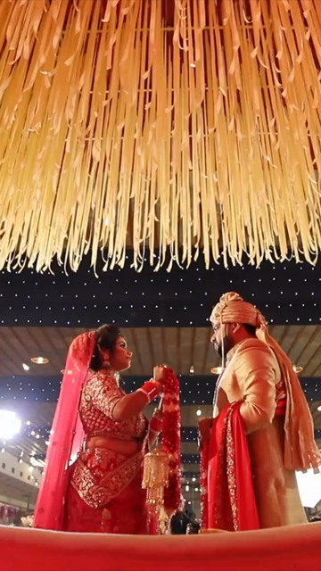 Vertical Shot of Bride and Groom During Jaimala Ceremony at Indian Wedding