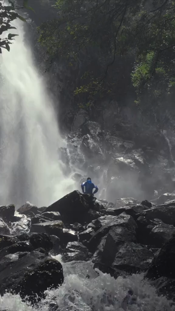 Vertical Shot of Man Standing near Motigudda Waterfall at Karnataka India