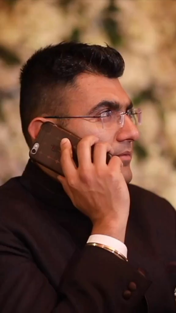 Vertical Shot of Man Talking on Phone During an Indian Wedding